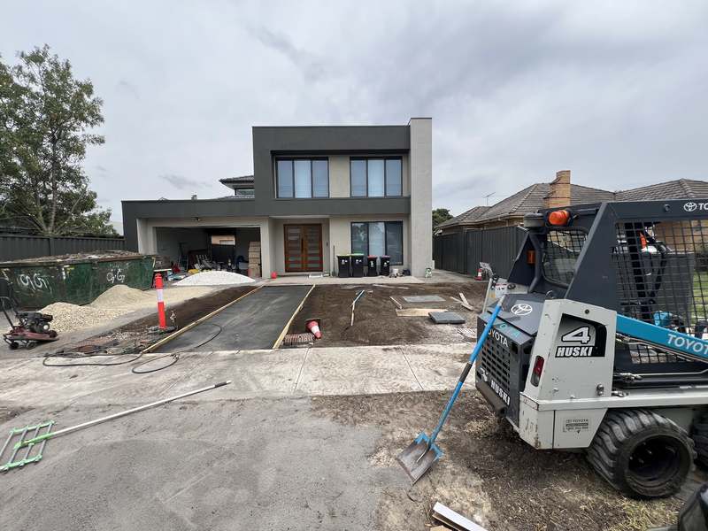 The driveway being poured with a skid steer on site