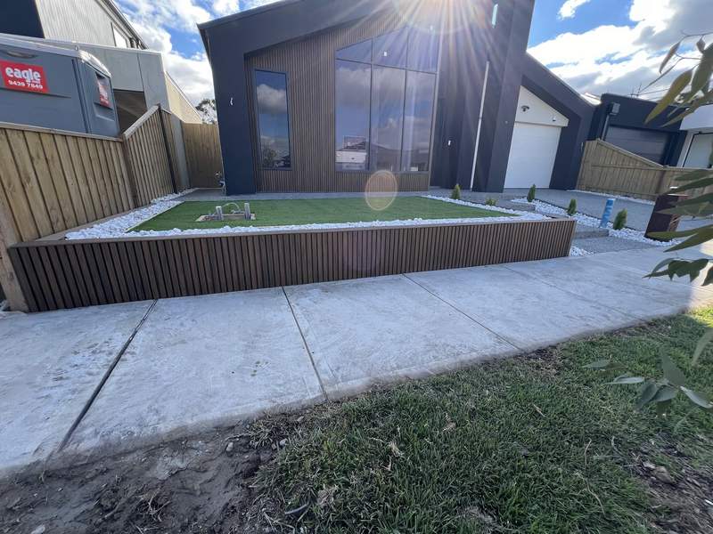 A finished front yard turf terrace in a slat-clad planter