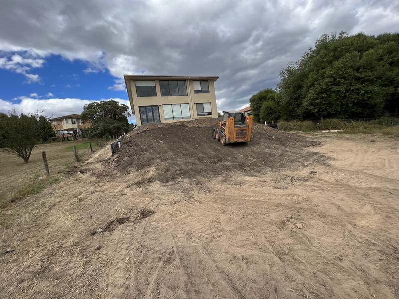 The bare sloping block behind the house before work began